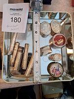 Photo of all twelve items on a mirrored tray showing the detailed designs and a measuring tape for scale.