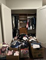 Closet contents and boxes of folded clothes and shoes
