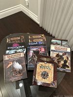 All books arranged on a glass table showing front covers and some back covers.