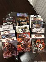 Array of RPG books on a dark wood table including Dungeons & Dragons and other fantasy roleplaying titles.