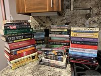 Photo showing stacks of various books in different genres, including fiction, non-fiction, biographies, and language learning.