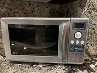 Front view of stainless steel Sanyo microwave with digital control panel and Japanese text.
