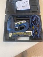 Arrow Nail Master 2 Electric Brad Nailer inside its molded black carrying case with power cord and instruction manual.