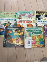 Photo of 8 children's books including 6 Berenstain Bears titles and 2 Mercer Mayer titles, arranged on light wood floor.
