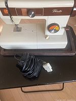 Front view of Brother Facesetter sewing machine with power cord and foot pedal placed in front.