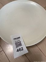 Plain white ceramic large dinner plate with minor visible wear.