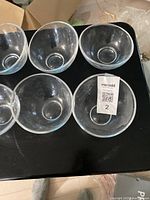 Top view of five clear glass bowls showing round shape and smooth appearance, solid base visible.