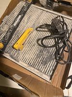 Overview of the Mastercraft wet tile saw showing the cutting surface, yellow blade guard, and power cord.