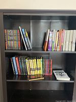 Black shelving with graphic novels, paperback books, and spiral notebooks displayed.