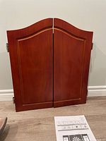 Closed wooden cabinet with double doors in reddish-brown finish.