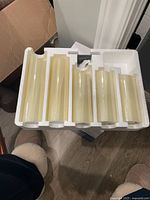 Five cream-colored flameless LED candles placed in white foam packaging, showing smooth cylindrical candles with rounded tops.
