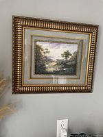 Full view of framed landscape print hanging on a wall showing the entire frame and artwork.