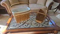 Two rectangular Longaberger baskets on a glass coffee table, one with fabric liner, one without.
