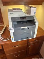 Front view of printer showing feeder, output tray and power cable