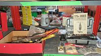 Box and tools on a shelf including grinder wheels, steel wire brushes, files, and a case with a Dremel rotary tool and bits.