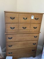 Front view of a solid wood dresser with six drawers and metal pull handles.