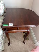 Front left view showing tabletop, drawer front, cabriole legs