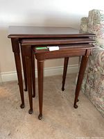 Three cherry nesting tables nested, front view