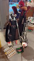 Overview of two golf bags with clubs, balls and accessories