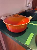 Orange Le Creuset Dutch oven with lid on kitchen counter
