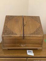 Closed carved wood memo box with ornate corner designs and keyhole in the middle