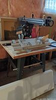 Sears Craftsman radial arm saw mounted on a metal stand in basement workshop.