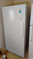 Exterior view of upright freezer showing single white door with handle and brand decal