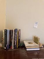 Books displayed on a wooden surface, showing titles and decorative bookends at each end holding the books upright.