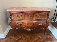 Front view of Louis XV style wood chest of drawers with marble top