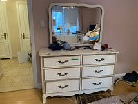 Front view of the six-drawer dresser with ornate handles and large mirror on top showing overall design and condition.