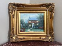 Frontal view of the framed oil painting showing the cottage scene with geese and the decorative gold wood frame.
