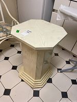 Front angled view showing the octagonal top and molded edges, positioned on a tiled floor.