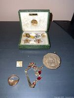 Overall lot arranged on table showing box with pins and items laid out