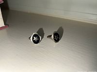 Two matching gold rings side by side on a white surface