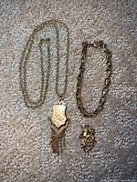 Full view of necklace with shield pendant, link bracelet, and unicorn pendant