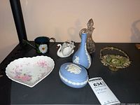 Overview of all items including 2 Wedgwood jasperware pieces, Goebel swan figurine, metal basket, cruet, heart-shaped dish, miniature watering can, and mug