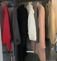 Photo of all seven coats and blazers hanging on a rack showing color and variations in length
