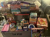 Full view of the lot showing various board games, puzzles, electronic games, and toys displayed on a table.