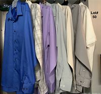 Photo showing six men's dress shirts in various colors and one additional white polo shirt and black vest visible in the lot