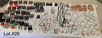 Full overhead view of assorted costume jewelry laid out on a table showing variety of necklaces, earrings, and bracelets including beaded and hoop styles.