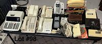 Wide view showing all items in the lot, including telephones, adding machine, answering machines, and wires.