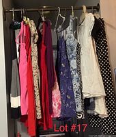 Photo of 9 women's dresses on hangers showcasing different colors and patterns including solid colors, floral prints, and polka dots.