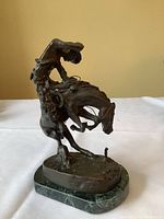 Full front view of bronze sculpture on marble base