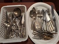 Overall view of mixed cutlery in plastic basket and white tray