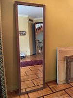 Full front view of mirror leaning against wall