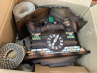 Overall view of clock in original box with packing materials