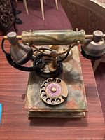 Front and top view showing green marble handset and base with brass stand and black coiled cord.