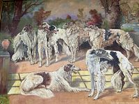 Close-up of group of Borzoi dogs on terrace with garden backdrop.