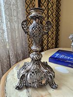 Front view of candlestick showing ornate base and latticework body