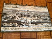 Front view of tapestry showing entire architectural garden scene with palace, gardens, figures, and carriages.